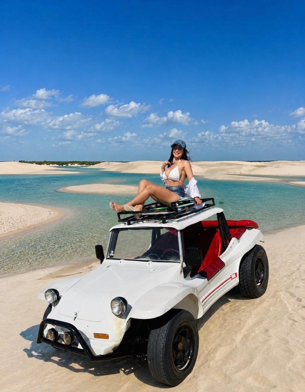 Visitante nas dunas dos Pequenos Lençóis com lagoas e coqueiros ao fundo