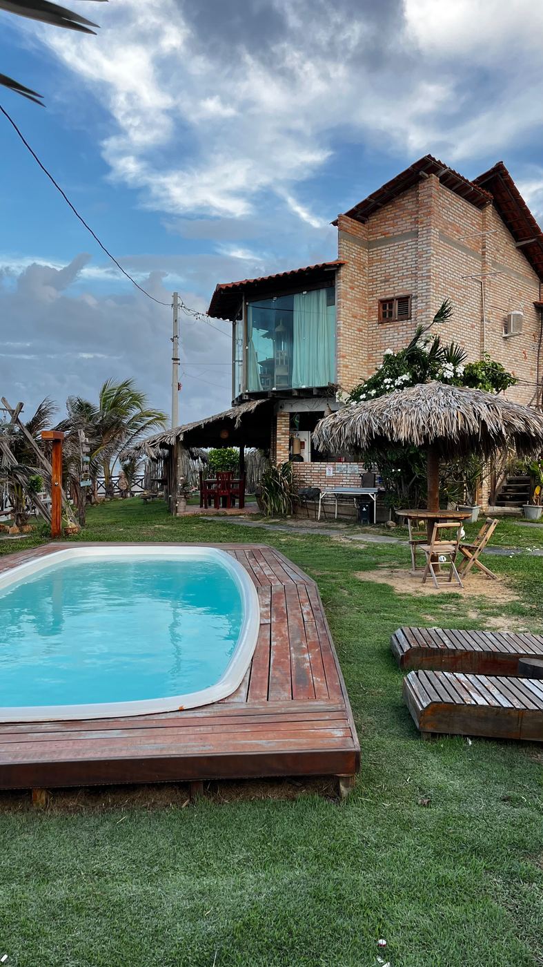 Piscina de madeira com vista para o casarão de tijolo aparente