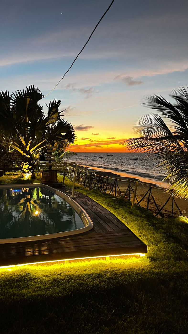Piscina ao entardecer com o mar ao fundo