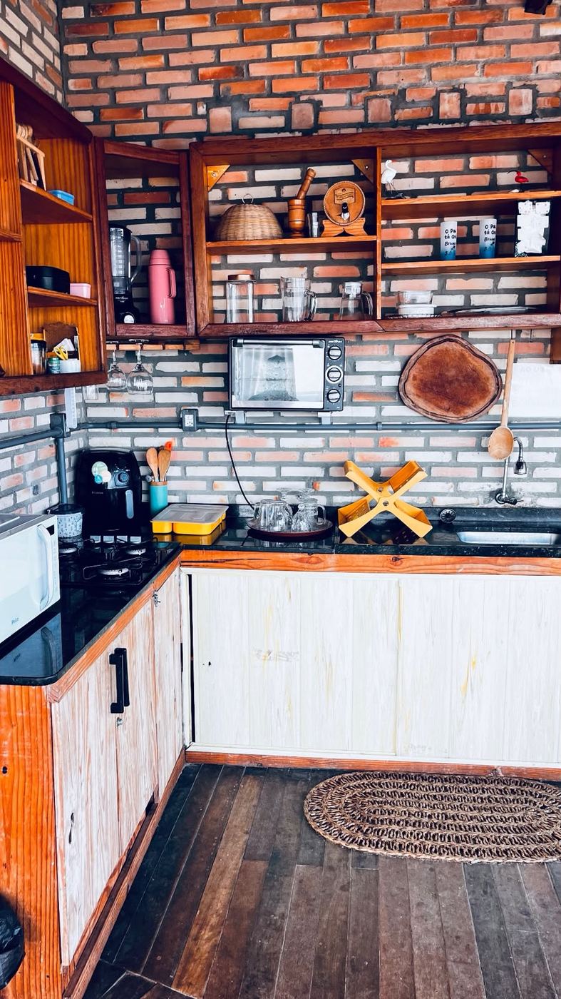 Cozinha compartilhada com parede de tijolo aparente